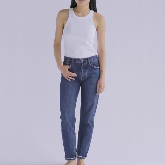 10-second video of a fit model presenting the B O R O デニム (BORO DENIM) 'Tokyo Eagle bird' jeans. The model makes a full 360-degree turn, highlighting the jeans' slim silhouette, tapered waist, and unique vintage charm. The roll-up style is demonstrated for a playful, casual flair.